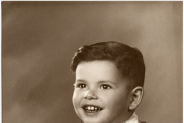 [Dos hermanitos sonrientes posando uno al lado del otro y uno de ellos posando sentado en un felpudo con una pelota en la mano]