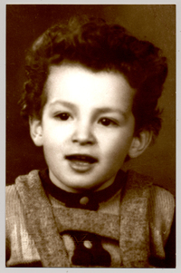 [Niño sonriente con chaleco abrochado y pechera de lana]