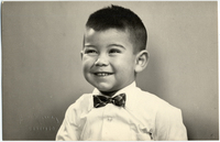 [Niño moreno de pelo corto con camisa blanca y humita cuadrillé]