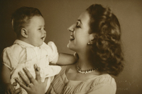 [Mujer sonriendo con su guagua en los brazos]