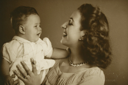 [Mujer sonriendo con su guagua en los brazos]