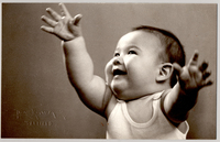 [Bebé con facciones orientales, con una polera blanca sin mangas, sonriente y los brazos en alto]