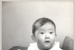 [Bebé de rasgos asiáticos, vestido completamente de blanco)