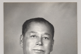 [Hombre de rasgos algo asiático traje oscuro y corbata a rayas]