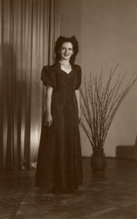 [Mujer joven de pie y vestido largo bordado negro]