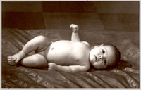 [Bebé desnudo acostado sobre un colchón]