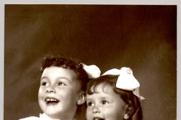 [Dos hermanas sentadas riéndose con vestido mangas cortas englobadas y bordados de colores y cintas blancas en el pelo]