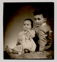 [Niño sentado con su hermana chica con la cabeza rapada]