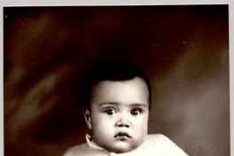 [Guaguita de vestido chaleco y zapatos de lana sentada sobre un felpudo]