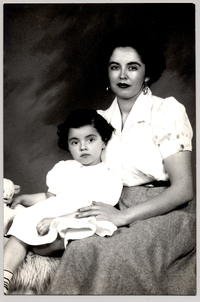 [Madre e hija vestidas con ropa blanca y sentadas sobre un felpudo]