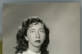 [Mujer joven posando sentada con un vestido de pechera blanca y mangas cortas con vuelos]