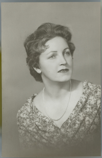 [Mujer rubia de ojos claros, vestido floreado y escote en V]