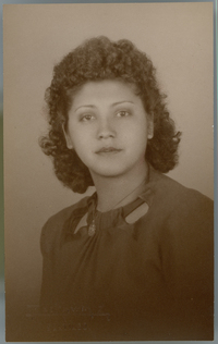 [Mujer joven de vestido oscuro, regordeta, pelo crespo hasta los hombros]