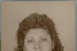 [Mujer joven de vestido oscuro, regordeta, pelo crespo hasta los hombros]