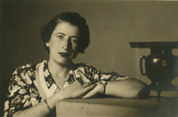 [Mujer con una solera estampada con flores, apoyada en un mueble]