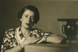 [Mujer con una solera estampada con flores, apoyada en un mueble]