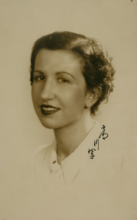 [Mujer joven de pelo corto ondulado y blusa blanca]