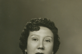 [Mujer adulta de pelo rizado, aretes y traje oscuro]