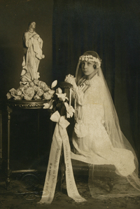 Gabriela Doyere Contreras en el día de su Primera Comunión, hincada frente a la imagen de la virgen