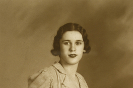 [Mujer joven vestida con una solera a cuadros, entallada, con un cinturón de la misma tela]