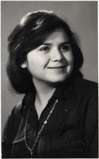 [Muchacha de cara regordeta peinada al lado y sonriente]