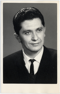 [Hombre adulto vestido de traje color negro y sonriente]