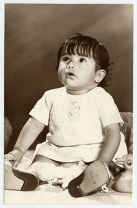 [Bebita sentada con unos juguetes a su alrededor]