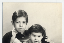 [Dos niños [hermanos] posando con varios juguetes]