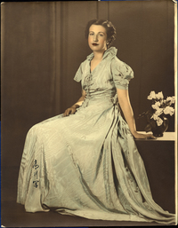 [Mujer joven de pelo corto ondulado con un vestido largo de color verde]