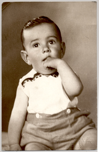 [Niñito peinado hacia atrás, pantalón corto y blusa blanca sin manga, con un dedo metido en la boca]