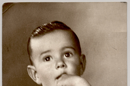 [Niñito peinado hacia atrás, pantalón corto y blusa blanca sin manga, con un dedo metido en la boca]