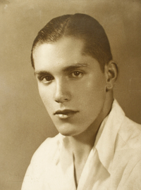 [Hombre joven de facciones finas con una camisa blanca de cuello alto]