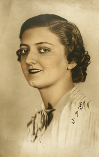 [Jovencita de pelo ondulado ojos claros y boca pintada posando de lado]