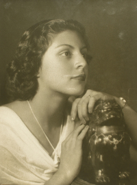 [Joven mujer de vestido blanco con las manos sobre una figura [dragón de plaqué]