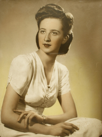 [Joven y esbelta mujer posando sentada con sus manos sobre la falda de su vestido blanco]