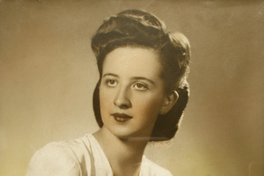 [Joven y esbelta mujer posando sentada con sus manos sobre la falda de su vestido blanco]