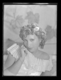 [Mujer con flores en el pelo tocando su mejilla]