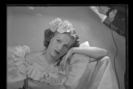 [Mujer con flores en el pelo, apoyando su mejilla en la mano]