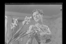 [Mujer de pie junto a un florero]