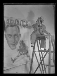 [El muñeco don Pánfilo arriba de una escalera colocando un cartel anunciando a Agudiez]