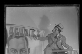 [El muñeco don Pánfilo arriba de una escalera colocando un cartel anunciando a Agudiez]