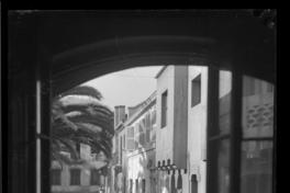 [Vista de una calle, mujer junto a dos niños, sentada en la parte posterior de un auto]