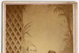 [Padres sentados en un sillón de madera y una bebé en la falda de la madre]