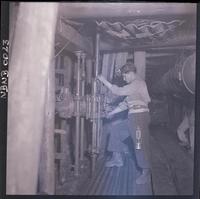 [Mineros junto a maquinaria en la galería subterránea de la mina]