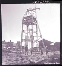 [mineros trabajando al exterior de la mina, y la estructura del ascensor]