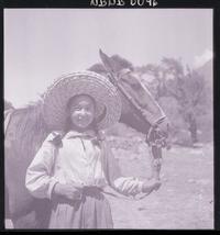 [Niña campesina junto a un caballo, en el campo]
