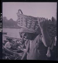 [Pescador sosteniendo un canasto con pescados]