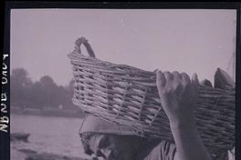 [Pescador sosteniendo un canasto con pescados]