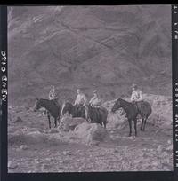 [Funcionarios uniformados junto a civiles montados a caballo en la montaña]