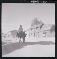 [Campesino a caballo por una calle rural]